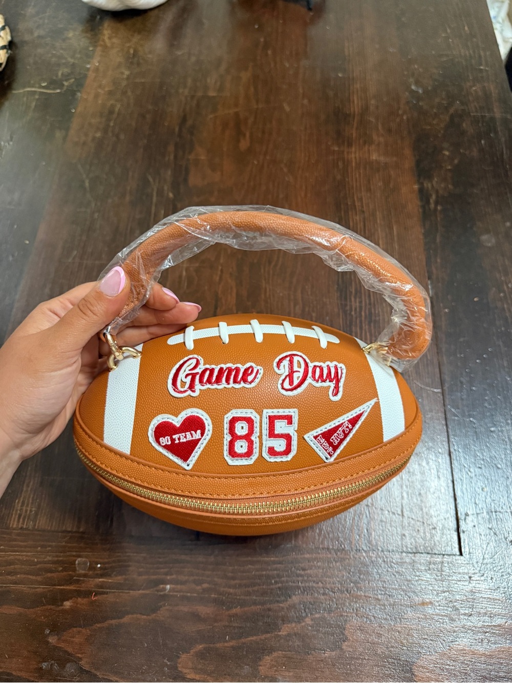 Brown Football-Shaped Crossbody Bag with Red Accents